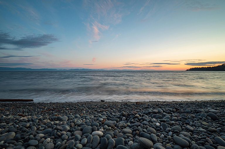a sunrise from the shore of a rocky beach in BC